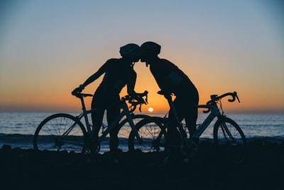 剪影摄影的两个人站在海滨附近的自行车

